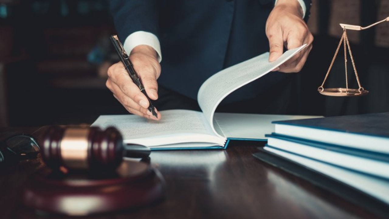 man writing in book gavel on table